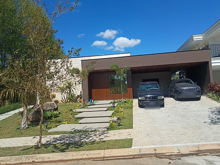 Casa térrea entregue, com fachada em madeira, cobertura da garagem e paisagismo